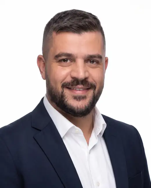 Mousa Alhelo, founder of E-SAFQA, formal portrait in a navy suit on a white background